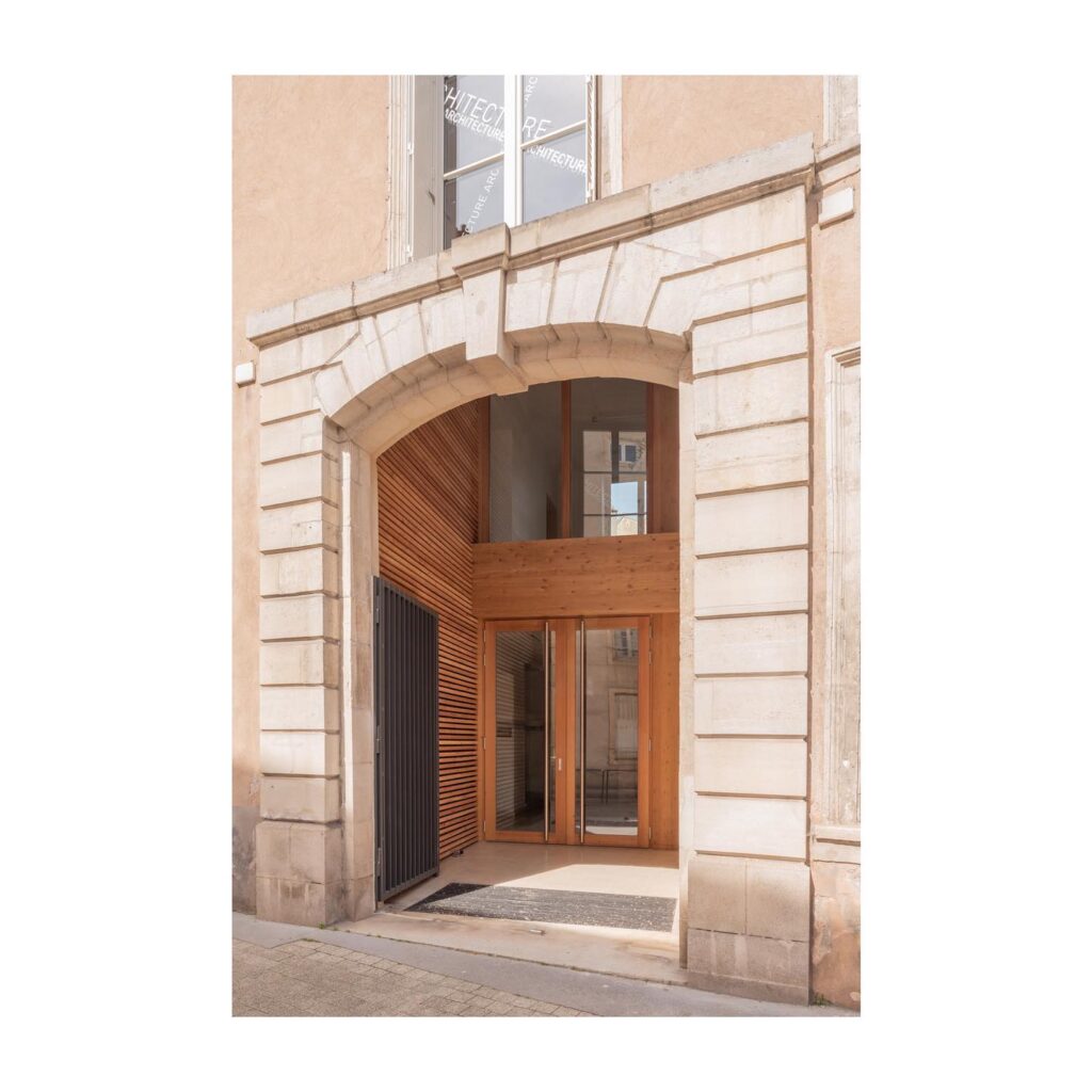 Porte d’entrée contemporaine en bois sur mesure intégrée à une façade ancienne